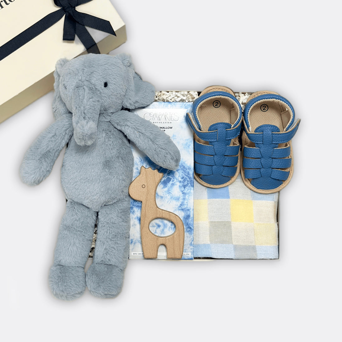 Bobbie Elly Small Checkered Muslin Square | Blue Baby Sandals | Denim Blue Marshmallow Crisp Milk Chocolate Bar Gege Wooden Teether, the best-customized gift box and gifts for her and for him from Inna Carton online shop Dubai, UAE